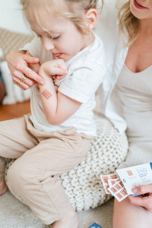 woman applying crosstape crosspatches on a child to help with skin irritation