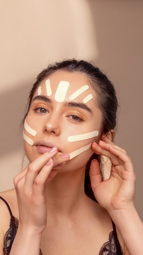 woman applying curetape beauty on her face and forehead