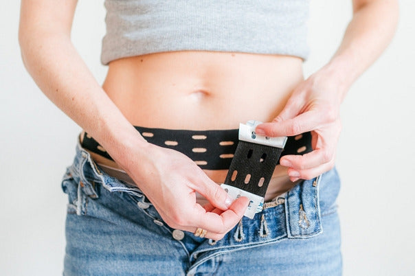 woman applying Curetape Punch to help with a period pain