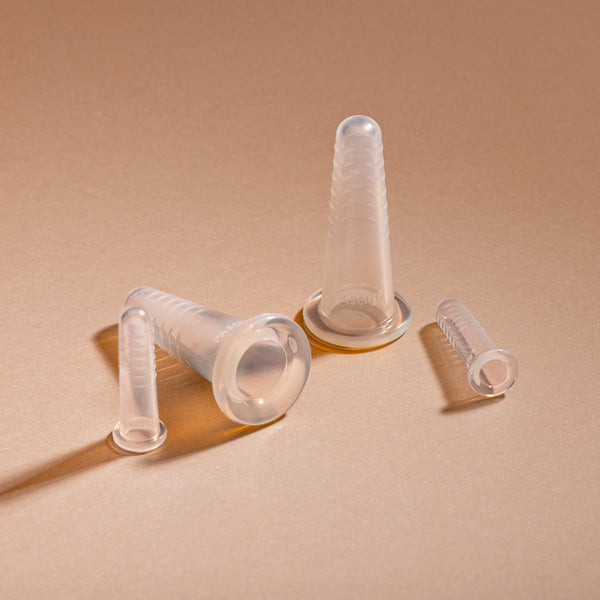 FASCIQ silicone face cupping tools in multiple sizes arranged on a beige surface.
